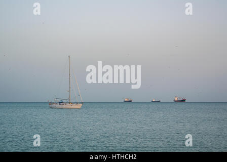 MALAGA, ESPAGNE - 16 février 2014 : un seul bateau de pêche en mer avec un Meditarrain beaucoup de mouettes à l'arrière-plan dans la soirée près de Malaga, un Banque D'Images