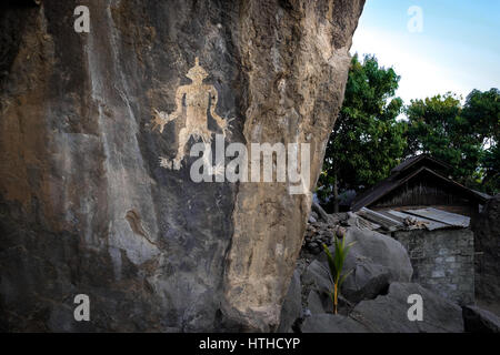 Une ancienne figure humaine peinte sur une falaise naturelle dans le village de Lamagute, Ile APE Timur, Lembata, Nusa Tenggara est, Indonésie. Banque D'Images