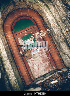 Vue de l'extérieur de l'hôpital psychiatrique abandonné avec de l'amiante sur la porte d'avertissement Banque D'Images