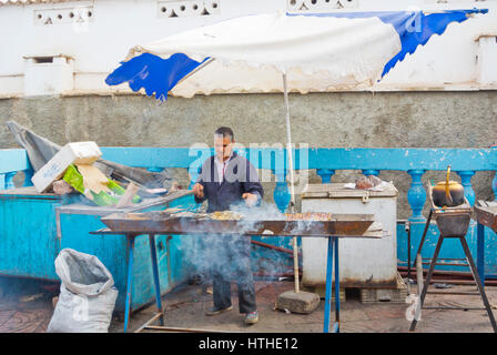 Man grilling sardines, Marche, principal marché municipal, Sidi Ifni, Guelmim-Oued région, Maroc Banque D'Images