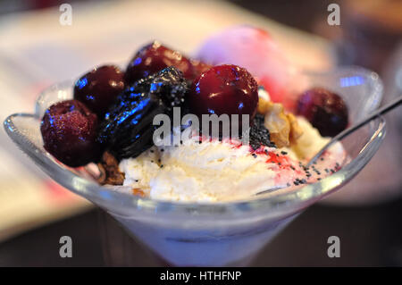 La crème glacée aux fruits avec les cerises et les pruneaux dans un café. Banque D'Images