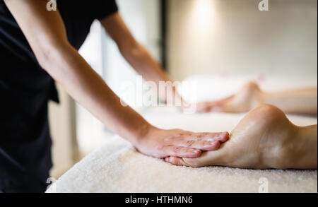 Masaging masseuse pieds de personne, dans un salon de massage Banque D'Images