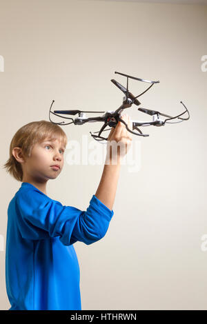 Petit enfant jouant avec drone. Boy holding quadcopter dans sa main, se préparant à voler. La technologie, les loisirs jouets concept Banque D'Images