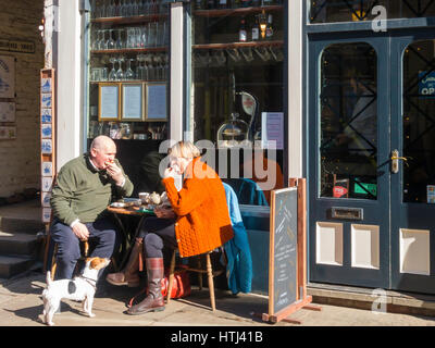 Un couple avec un Jack Russell chien appréciant le déjeuner en été sunshine au Blitz café Whitby, North Yorkshire Angleterre Banque D'Images