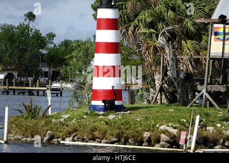 Un singe marche devant la maquette de phare sur Monkey Island, Homosassa river, en Floride. Administré par l'Homosassa Riverside Resort Banque D'Images