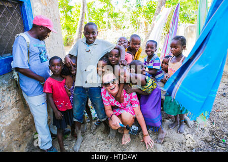 L'exploration touristique femelle village local. Posant avec des enfants locaux. Banque D'Images