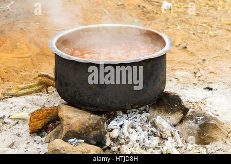 Cuisson de la soupe dans une casserole sur feu de camp. Banque D'Images