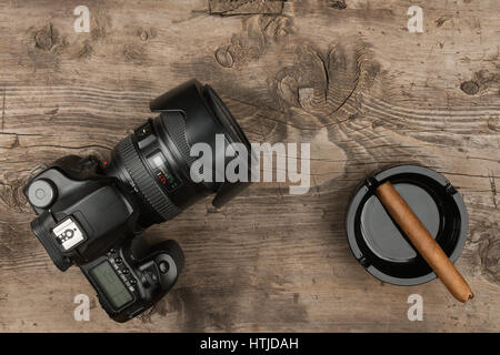 Appareil photo numérique et d'un cendrier avec un cigare sur un vieux bois. Vue de dessus Banque D'Images