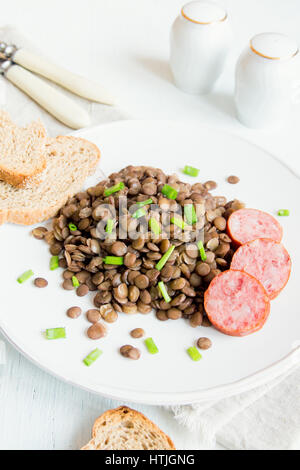 Avec des lentilles vertes (saucisse cotechino) on white plate Banque D'Images