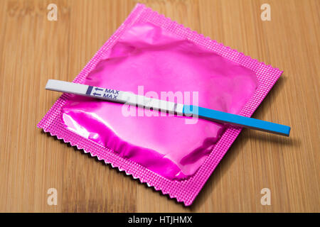 Des tests de grossesse et le condom sur table en bois Banque D'Images