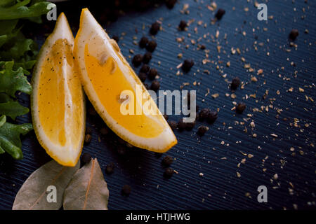 Arrière-plan de l'alimentation noire avec des tranches de citron, des herbes aromatiques et épices, copy space, vue du dessus Banque D'Images