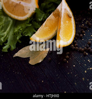 Arrière-plan de l'alimentation noire avec des tranches de citron, des herbes aromatiques et épices, copy space, vue du dessus Banque D'Images