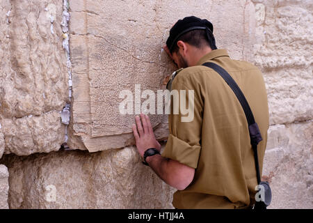 Un soldat israélien armé prie le mur occidental ou le Kotel dans la vieille ville de Jérusalem-est Israël Banque D'Images