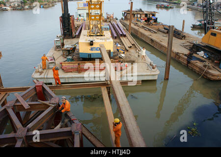 HO CHI MINH ville, VIET NAM, Groupe de travail sur les travailleurs d'Asie site de construction, construire l'homme vietnamiens pont sur l'eau, ils travaillent sur l'échafaudage en acier Banque D'Images