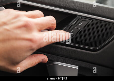 Côté conducteur porte pousse bouton de casiers multisegment de luxe voiture. La photo en gros plan avec selective focus Banque D'Images