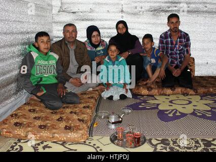 De 0001 sous embargo Lundi 13 mars Jamil Hussein Hawayish (deuxième à gauche), qui a été témoin de décapitations par État islamique avant de fuir la Syrie, se trouve dans la cabane en bois qu'il a construit dans la région de Akkar dans le nord du Liban avec l'appui de l'agence d'aide du HCR et de préoccupation, avec sa famille (de gauche à droite) Khaled, 12, 14, Khouloud, Samia, 7, Helwa, 45, et 20, Mhammad. Banque D'Images