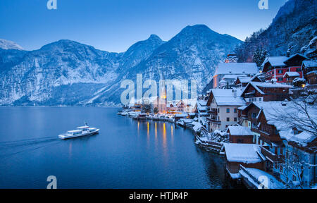 Vue de carte postale classique de la célèbre ville au bord du lac de Hallstatt dans les Alpes avec le navire à passagers traditionnels en hiver Hallstattersee mystique twilight Banque D'Images