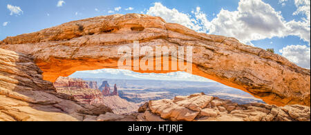 Vue panoramique du célèbre Mesa Arch, véritable icône de l'Ouest américain, illuminé en or belle lumière du matin sur une journée ensoleillée avec ciel bleu et Banque D'Images