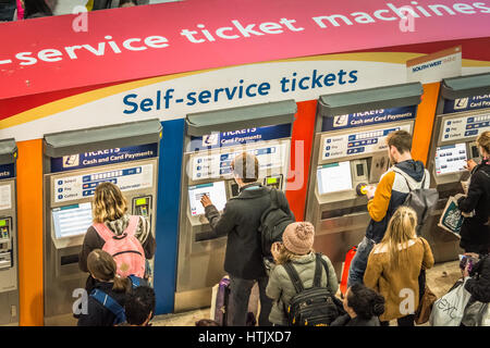 Les passagers du train l'achat de billets à un distributeur de billets libre-service à Londres, Royaume-Uni Banque D'Images