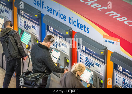 Les passagers du train l'achat de billets à un distributeur de billets libre-service à Londres, Royaume-Uni Banque D'Images