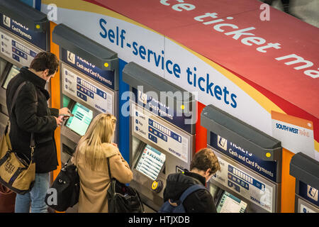 Les passagers du train l'achat de billets à un distributeur de billets libre-service à Londres, Royaume-Uni Banque D'Images