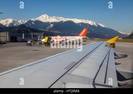 Vue depuis la fenêtre d'un avion à l'aéroport d'Innsbruck, Autriche. Montagnes dans les Alpes autrichiennes dans l'arrière-plan, et d'un Airbus d'Easyjet au milieu. Banque D'Images