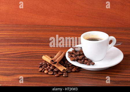 Tasse de café avec des grains de café et des bâtons de cannelle Banque D'Images