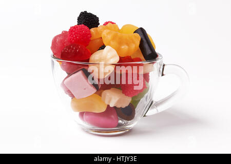 Bonbons colorés dans bol en verre on white Banque D'Images