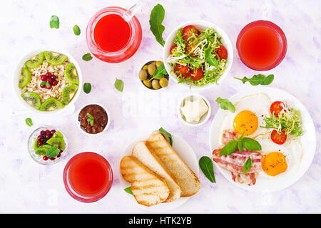 Petit-déjeuner anglais - œuf frit, tomates et bacon. Le petit-déjeuner pour deux. Le gruau. Mise à plat. Vue d'en haut Banque D'Images