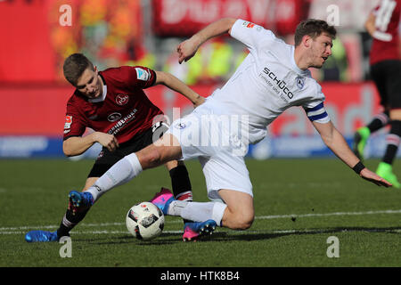 Nuremberg, Allemagne. Mar 12, 2017. L'Nremburg Dennis Lippert (L) et Bielefeld's Fabian Klos rivalisent pour le ballon pendant le match de football Bundesliga 2 allemande entre 1. FC Nuremberg et l'Arminia Bielefeld dans le stade Grundig à Nuremberg, Allemagne, 12 mars 2017. (CONDITIONS D'EMBARGO - ATTENTION : En raison de l'accréditation, le LDF guidlines n'autorise la publication et l'utilisation de jusqu'à 15 photos par correspondance sur internet et dans les médias en ligne pendant le match.) Photo : Daniel Karmann/dpa/Alamy Live News Banque D'Images