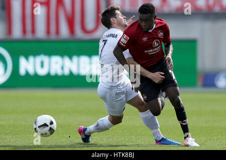 Nuremberg, Allemagne. Mar 12, 2017. Le Edgar Salli (R) et Bielefeld's Michael Goerlitz rivalisent pour le ballon pendant le match de football Bundesliga 2 allemande entre 1. FC Nuremberg et l'Arminia Bielefeld dans le stade Grundig à Nuremberg, Allemagne, 12 mars 2017. (CONDITIONS D'EMBARGO - ATTENTION : En raison de l'accréditation, le LDF guidlines n'autorise la publication et l'utilisation de jusqu'à 15 photos par correspondance sur internet et dans les médias en ligne pendant le match.) Photo : Daniel Karmann/dpa/Alamy Live News Banque D'Images