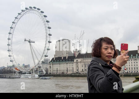 Londres, Royaume-Uni. 12 mars 2017. Un touriste de Chine continentale prend une photographie selfies Westminster Bridge. À la suite de la décision du Royaume-Uni de voter pour Brexit, la faiblesse de l'pound a fourni une opportunité intéressante pour les touristes d'outre-mer pour visiter le Royaume-Uni. Crédit : Stephen Chung / Alamy Live News Banque D'Images
