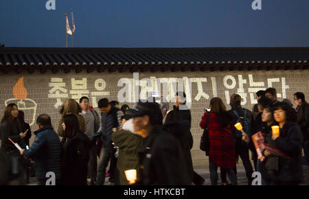 La politique de la Corée du Sud, Mar 11, 2017 : personnes participent à une manifestation aux chandelles à l'occasion après que la Cour constitutionnelle a confirmé vendredi l'impeachment du président Park Geun-hye à Séoul, Corée du Sud. Les caractères coréens sur le mur de la porte Gwanghwamun lire,'Candlelight n'est pas soufflée". La décision Park le premier président du pays à être licenciés par l'impeachment parlementaire. Park est devenu un citoyen ordinaire et devrait faire face à l'interrogatoire par le ministère public. Park a été destitué par le parlement en décembre dernier pour avoir prétendument laissant son ami de longue date Choi Soon-sil s'ingérer dans Banque D'Images