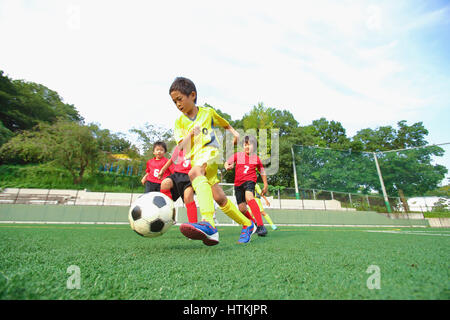 Enfants jouant au football japonais Banque D'Images