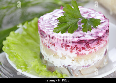 Salade 'Hareng sous un manteau de fourrure'sur une plaque blanche Banque D'Images