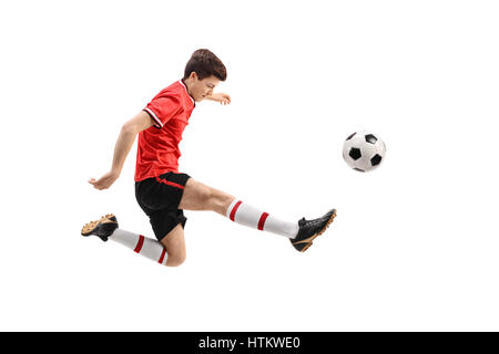 Teenage soccer player kicking football un isolé sur fond blanc Banque D'Images