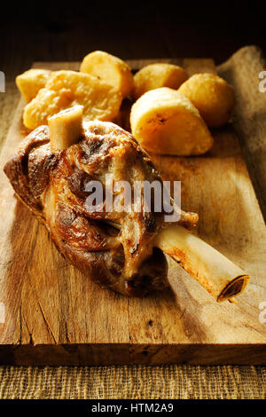 Rôti de bœuf sur l'os avec des pommes de terre en studio shot Banque D'Images