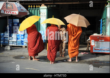 Femme donnant de la nourriture aux moines, au Cambodge. C'est une longue tradition en Asie du sud-est que les moines bouddhistes sortent pour recevoir des aumônes au matin du temps. Banque D'Images