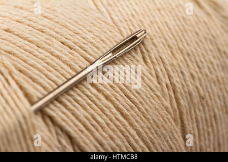 Macro close up metal aiguille à coudre et des yeux de couleur claire sur tiroir thread Banque D'Images