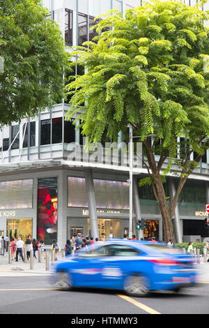 Taxi passer le long de la rue Orchard, Singapore Banque D'Images