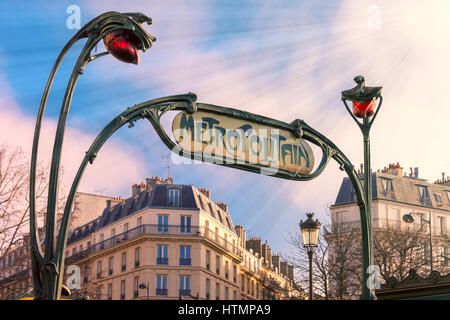 Panneau d'entrée Art Nouveau traditionnel pour le Metropolitan et réverbères rouge, typique des immeubles parisiens dans l'arrière-plan, Paris, France Banque D'Images