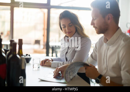 Happy business people habillés formellement flirting in cafe Banque D'Images