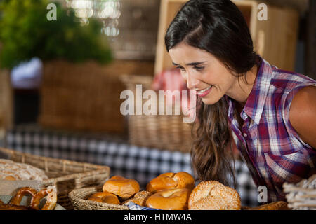 Smiling woman looking at pains dans counter at market Banque D'Images