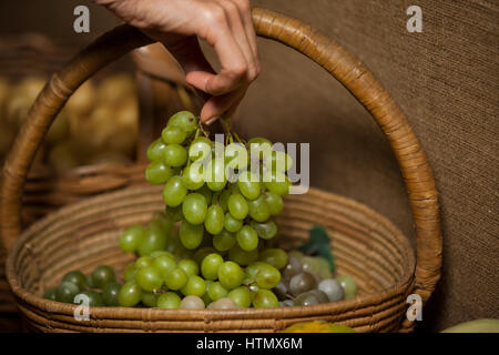 Main de femme achat en grappe de raisin dans le marché Banque D'Images