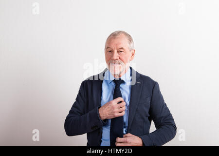 Senior man wearing blue shirt, veste et cravate, studio shot. Banque D'Images