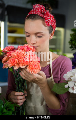 Fleuriste femme sentir un bouquet de fleur dans le magasin de fleurs Banque D'Images