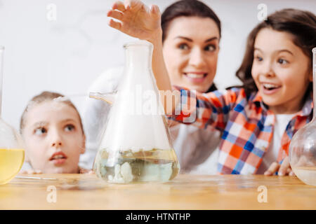 Réaction chimique. Focus sélectif d'une fiole d'être rempli de liquide chimique tout en se tenant sur la table Banque D'Images