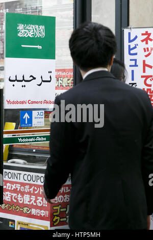 Tokyo, Japon. 14Th Mar, 2017. Un homme passe devant un drapeau de l'Arabie saoudite sur l'affichage à l'entrée du magasin Yodobashi Camera à Akihabara le 14 mars 2017, Tokyo, Japon. Le roi d'Arabie saoudite Salman bin Abdulaziz Al Saud est au Japon pour une visite de quatre jours, la première en 46 ans, de cimenter les relations commerciales entre les deux pays. Le roi, qui serait accompagné de 1000, a déjà rencontré le Premier ministre japonais Shinzo Abe et avec Prince héritier Naruhito du Japon. Credit : Rodrigo Reyes Marin/AFLO/Alamy Live News Banque D'Images