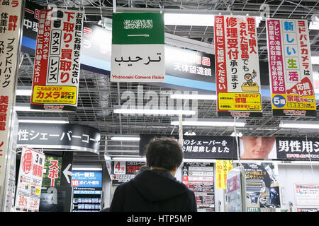 Tokyo, Japon. 14Th Mar, 2017. Un homme marche passé sous le drapeau de l'Arabie saoudite à l'affiche au magasin Yodobashi Camera à Akihabara le 14 mars 2017, Tokyo, Japon. Le roi d'Arabie saoudite Salman bin Abdulaziz Al Saud est au Japon pour une visite de quatre jours, la première en 46 ans, de cimenter les relations commerciales entre les deux pays. Le roi, qui serait accompagné de 1000, a déjà rencontré le Premier ministre japonais Shinzo Abe et avec Prince héritier Naruhito du Japon. Credit : Rodrigo Reyes Marin/AFLO/Alamy Live News Banque D'Images