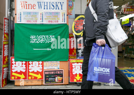 Tokyo, Japon. 14Th Mar, 2017. Un homme passe devant un drapeau de l'Arabie saoudite sur l'affichage à l'extérieur d'un magasin d'électronique à Akihabara le 14 mars 2017, Tokyo, Japon. Le roi d'Arabie saoudite Salman bin Abdulaziz Al Saud est au Japon pour une visite de quatre jours, la première en 46 ans, de cimenter les relations commerciales entre les deux pays. Le roi, qui serait accompagné de 1000, a déjà rencontré le Premier ministre japonais Shinzo Abe et avec Prince héritier Naruhito du Japon. Credit : Rodrigo Reyes Marin/AFLO/Alamy Live News Banque D'Images